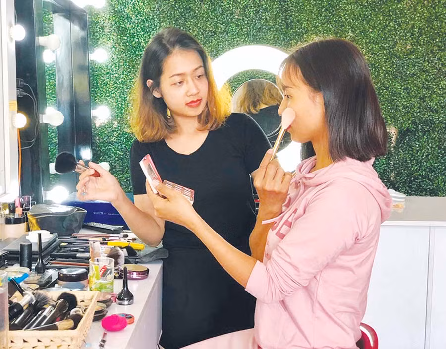  Chị Nguyễn Thị Bích Thảo (bìa trái) đang hướng dẫn cách trang điểm cho học viên. Ảnh: T.B