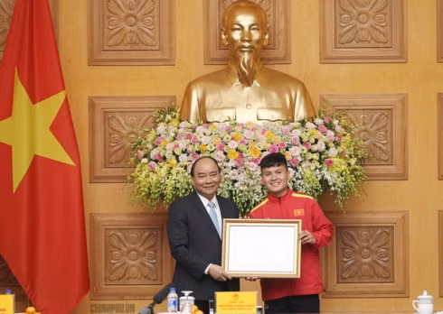 Thủ tướng trao Huân chương Lao động hạng Nhì cho cầu thủ Nguyễn Quang Hải. Ảnh: VGP/Quang Hiếu