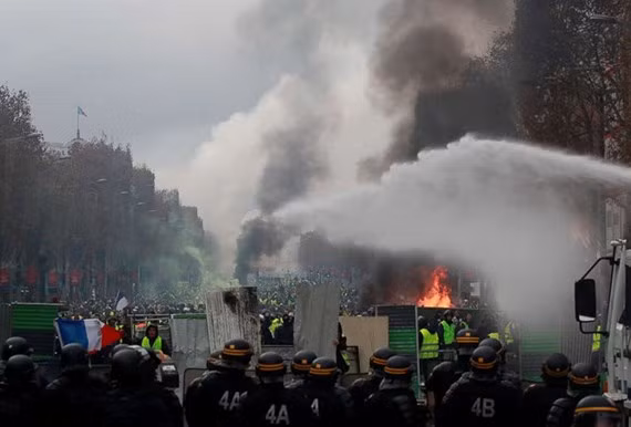 Người biểu tình đối đầu với cảnh sát tại Đại lộ Champs-Élysées. Ảnh: REUTERS