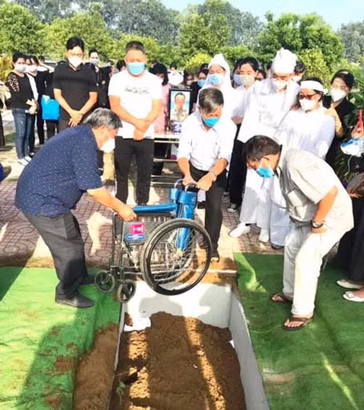 Đồng đội đưa chiếc xe lăn xuống mộ hôm tiễn thương binh Nguyễn Văn Thạnh về nơi an nghỉ cuối cùng