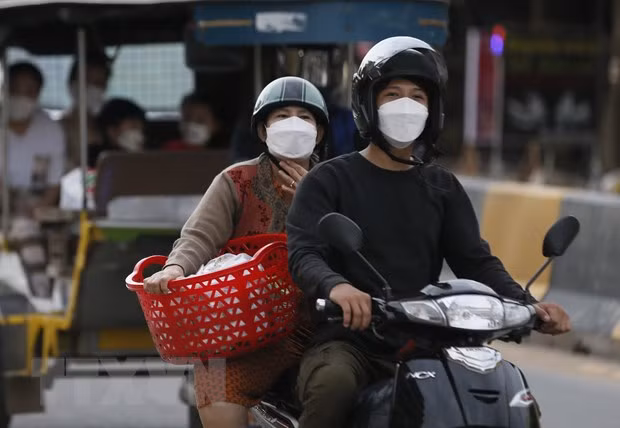  Người dân đeo khẩu trang khi tham gia giao thông ở Campuchia. (Ảnh: THX/TTXVN)
