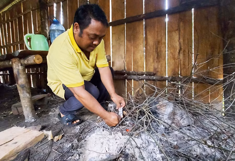Đi gác rừng gặp trời mưa to và lạnh, anh Nal đốt lửa để sưởi ấm. Ảnh: Hoành Sơn