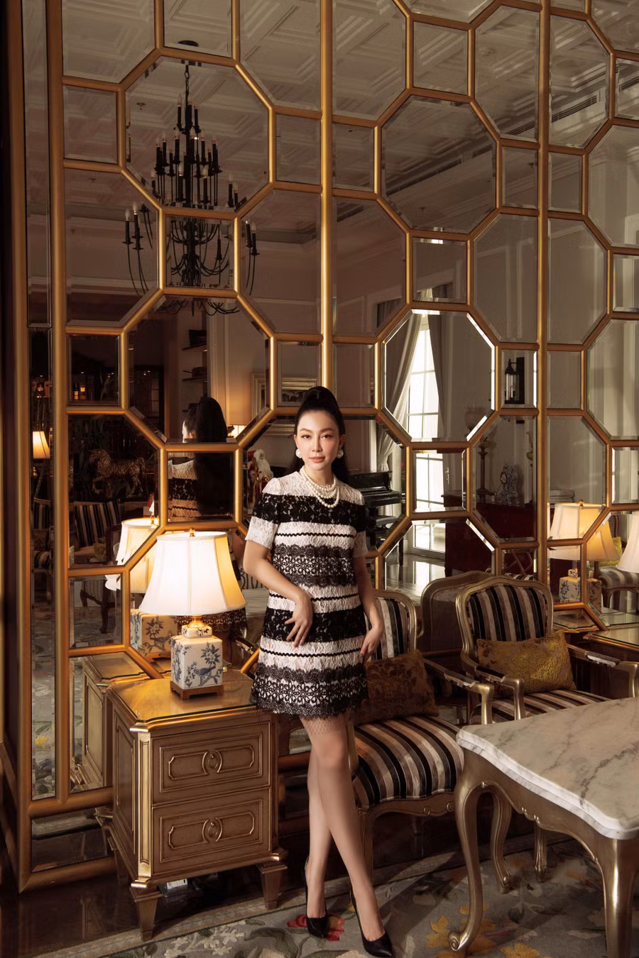 Linh Nga giấu đường cong trong chiếc đầm ren phom suông ngắn trên gối, xen kẽ những mảng ren đen trắng có độ dày mỏng khác nhau. Outfit đơn giản trở nên bắt mắt nhờ bộ phụ kiện ngọc trai sang trọng.