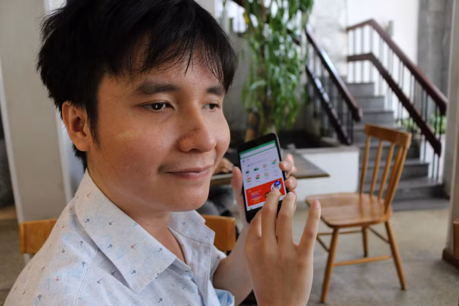 Anh Dương Tuấn Nam hướng dẫn cách sử dụng ứng dụng đọc màn hình để hỗ trợ sinh hoạt, công việc. Ảnh: P.T.N