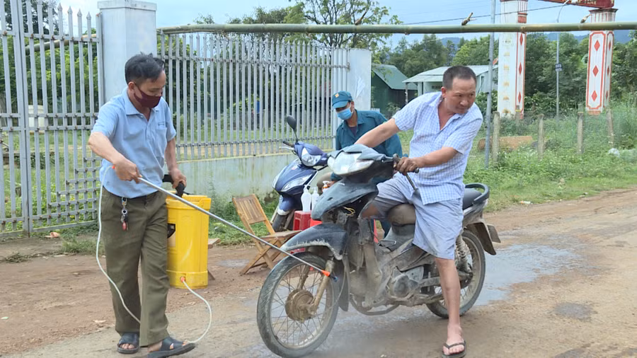  Nhân viên y tế phun hóa chất khử khuẩn cho phương tiện ra vào khu vực có ca bệnh bạch hầu. Ảnh: Như Nguyện