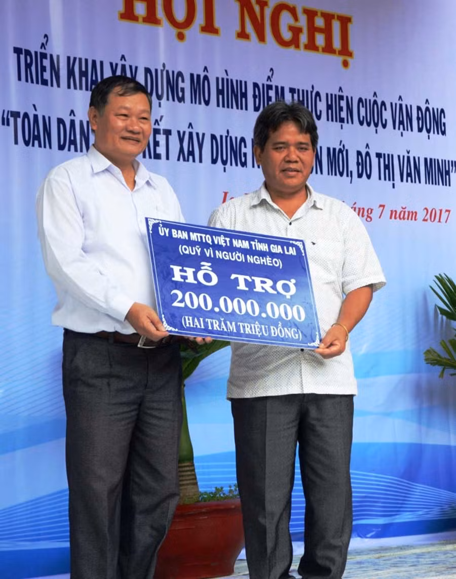 Chủ tịch Ủy ban MTTQ Việt Nam tỉnh Hồ Văn Điềm trao cho lãnh đạo Ủy ban MTTQ Việt Nam thị xã Ayun Pa số tiền 200 triệu đồng từ Quỹ vì người nghèo tỉnh để hỗ trợ nông dân xã Ia Rtô xây dựng mô hình nuôi dê Bách Thảo. Ảnh: Đức Phương