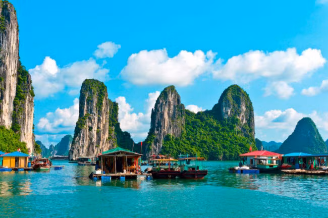 Vịnh Hạ Long, Việt Nam: Du khách có thể đi tàu tham quan làng chài Cửa Vạn nằm giữa các ngọn núi đá vôi trên biển.