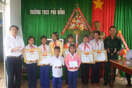 Ông Trần Văn Nghĩa (trái)- Phó Tổng Biên tập Báo Gia Lai, trao học bổng “Niềm hy vọng” cho 8 em học sinh nghèo vượt khó học giỏi của Trường THCS Phù Đổng (xã Ia Puch, Chư Prông). Ảnh:Phương Duyên