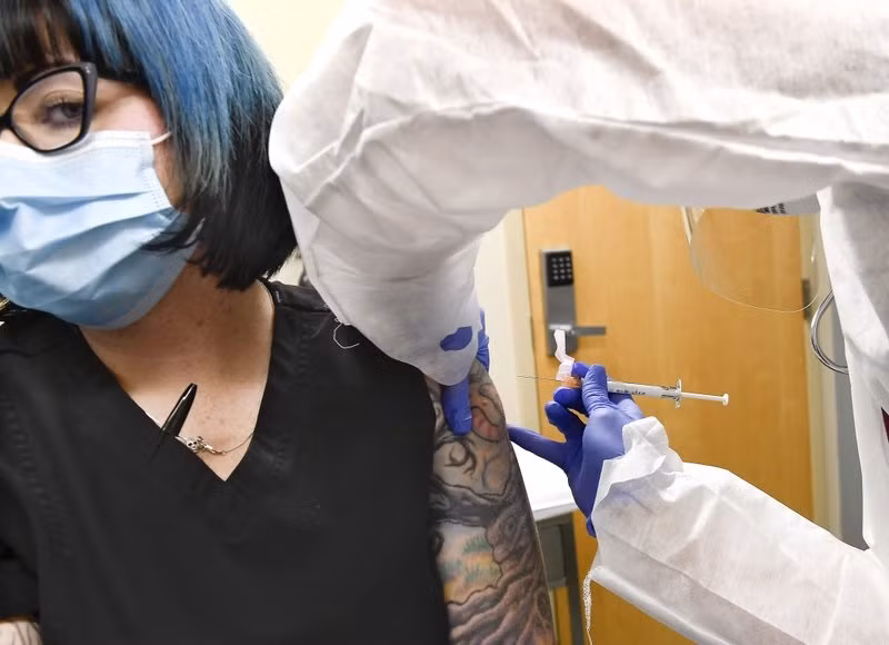  Y tá Kathe Olmstead tiêm vaccine thử nghiệm của Moderna cho cho tình nguyện viên Melissa Harting (bên trái) ở Harpersville, New York, Mỹ. Ảnh: AP.