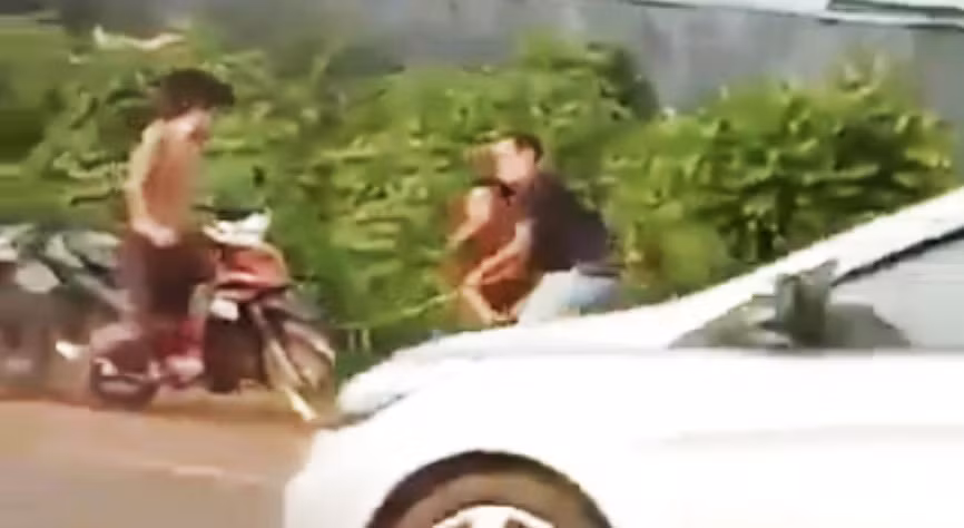 Một người mặc cảnh phục dùng gậy đánh một người đàn ông (ảnh cắt từ clip).