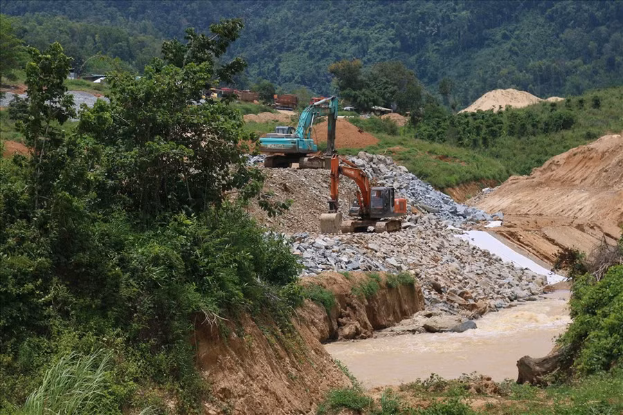 Đặc biệt, ở đập đất số 1 này, đơn vị thi công sẽ đắp đất tiếp đoạn còn lại của lòng sông dài 75m. Qua đó, nước sẽ chảy qua kênh dẫn dòng, cống lấy nước và tích tụ trong lòng hồ. Ảnh: Bảo Trung Đặc biệt, ở đập đất số 1 này, đơn vị thi công sẽ đắp đất tiếp đoạn còn lại của lòng sông dài 75m. Qua đó, nước sẽ chảy qua kênh dẫn dòng, cống lấy nước và tích tụ trong lòng hồ. Ảnh: Bảo Trung