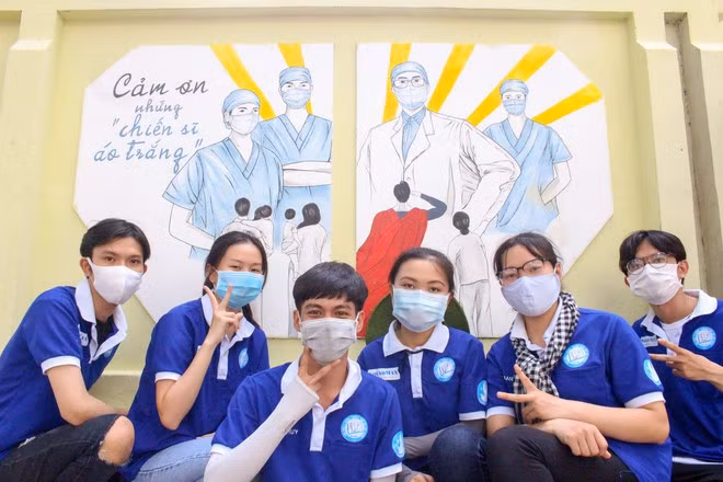 Bức tranh và SV tình nguyện của Đội Sống Xanh, Trường ĐH Y Dược TP.HCM ẢNH: PHƯƠNG LINH