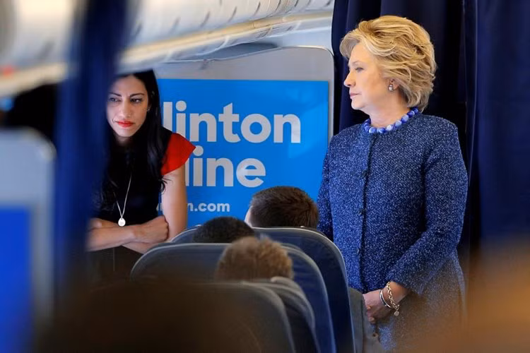 Bà Clinton nói chuyện với các phụ tá, trong đó có trợ lý Huma Abedin trên máy bay ở White Plains, New York hôm 28-10.