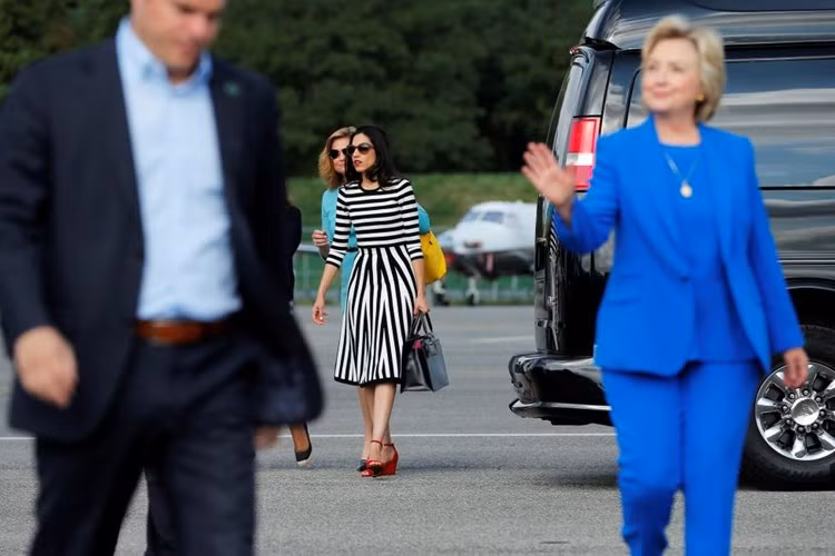 Bà Clinton tới một cuộc họp báo, theo sau bà là người phụ trách truyền thông Jen Palmieri và trợ lý Huma Abedin trên đường băng sân bay ở White Plains, New York.