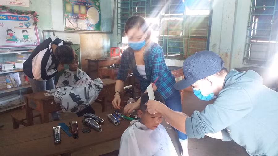 Các tình nguyện viên cắt tóc cho trẻ em có hoàn cảnh khó khăn tại xã Ia Blứ, huyện Chư Pưh. Ảnh: Ngọc Thu