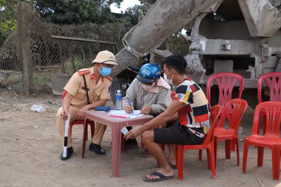 Lực lượng chức năng kiểm tra thông tin, cho người dân khai báo y tế. Ảnh: Quang Tấn