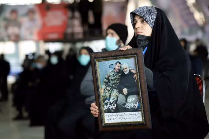 Một phụ nữ cầm ảnh của Tướng Soleimani trong sự kiện. Ảnh: Reuters