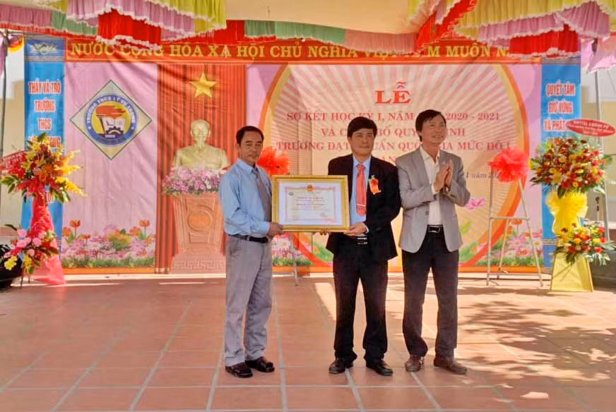 Ông Nguyễn Văn Vĩnh-Trưởng phòng Giáo dục và Đào tạo huyện Krông Pa (bìa phải) trao bằng công nhận trường đạt chuẩn quốc gia cho Trường THCS Lý Tự Trọng.Ảnh.Vũ Chi