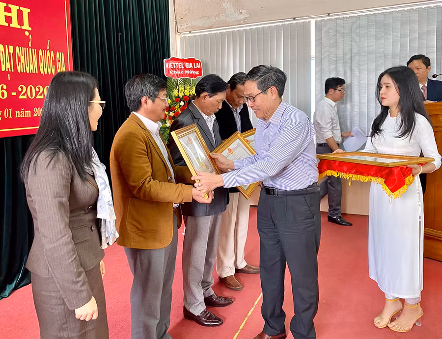 Giám đốc Sở GD-ĐT Lê Duy Định trao tặng bằng khen của Chủ tịch UBND tỉnh cho 8 tập thể có thành tích xuất sắc trong công tác xây dựng trường học đạt chuẩn quốc gia giai đoạn 2016-2020. Ảnh: Hồng Thi