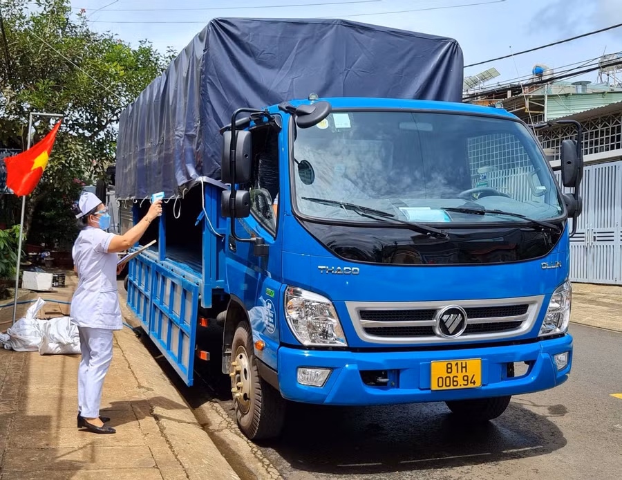Cán bộ y tế phường Ia Kring (TP. Pleiku) kiểm tra y tế một trường hợp tài xế xe luồng xanh vừa di chuyển về địa bàn phường để bốc dỡ hàng hóa. Ảnh: Lê Hòa