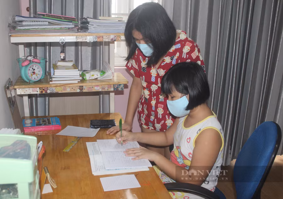Hai chị em Minh Vy và Minh Anh động viên, bảo ban nhau học và tập làm việc nhà phụ giúp mẹ. Ảnh: Mỹ Quỳnh