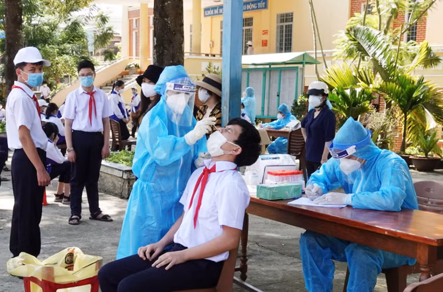  Nhân viên y tế lấy mẫu xét nghiệm cho học sinh tại Trường THCS Phạm Hồng Thái, TP. Pleiku. Ảnh: Hùng Linh