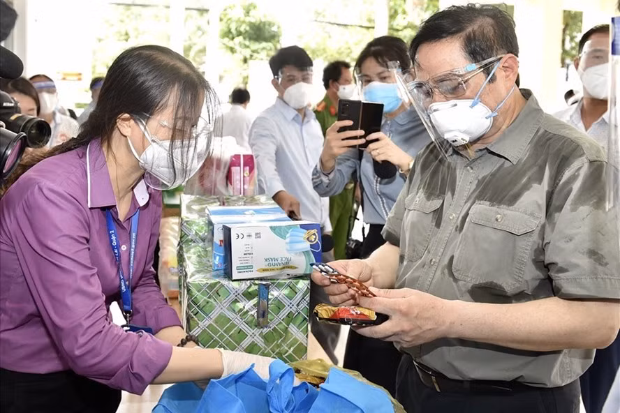 Thủ tướng Phạm Minh Chính kiểm tra công tác chống dịch tại TP.HCM, xem các loại nhu yếu phẩm, thuốc men... trong túi an sinh sẽ được cung cấp cho người dân. Ảnh: Chinhphu.vn