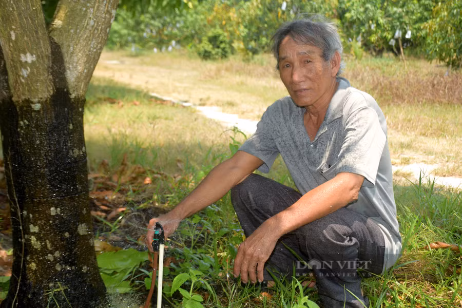 Nông dân Nguyễn Ngọc bên hệ thống tưới nước tiết kiệm. Ảnh: TB.