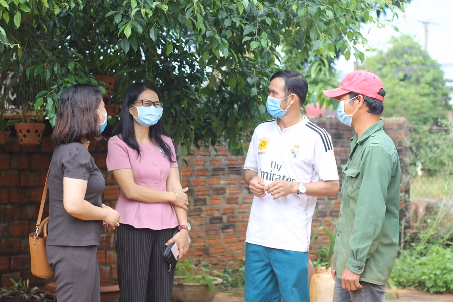 Bà Kpui H’Blê (thứ 2 từ trái qua)-Phó Chủ tịch UBND huyện Chư Sê thăm hỏi tình hình kinh tế, cuộc sống của các công dân trở về quê tránh dịch. Ảnh: Phan Lài