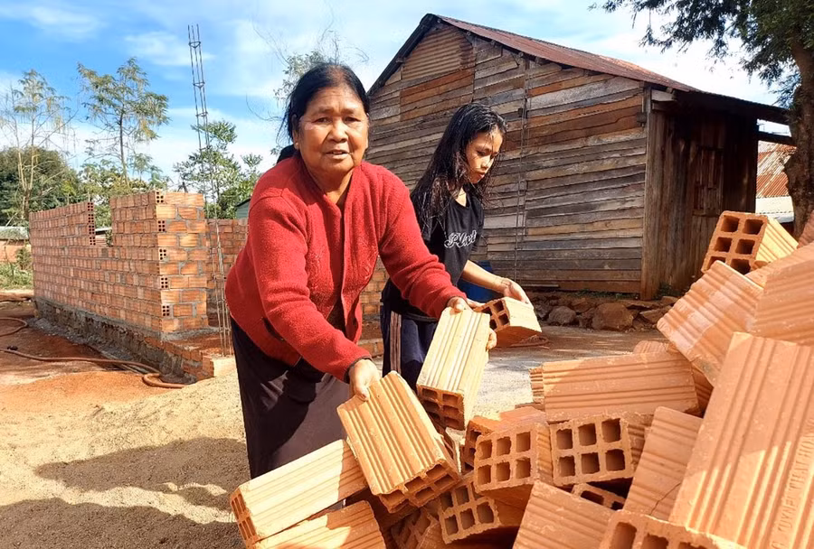  Mẹ và con gái của chị Nay HMen phụ giúp dọn mặt bằng để đổ vật liệu xây nhà mới. Ảnh: Thiên Di