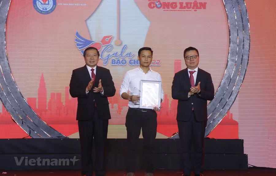 Ông Lê Quốc Minh, Chủ tịch Hội Nhà báo Việt Nam (phải) và ông Ông Lại Xuân Môn, Phó Trưởng Ban thường trực Ban Tuyên giáo Trung ương (trái) trao giải đặc biệt cho tác giả Lưu Trọng Đạt (Thông tấn xã Việt Nam) với tác phẩm 'Lời khẩn cầu từ dòng Đà Giang'. 