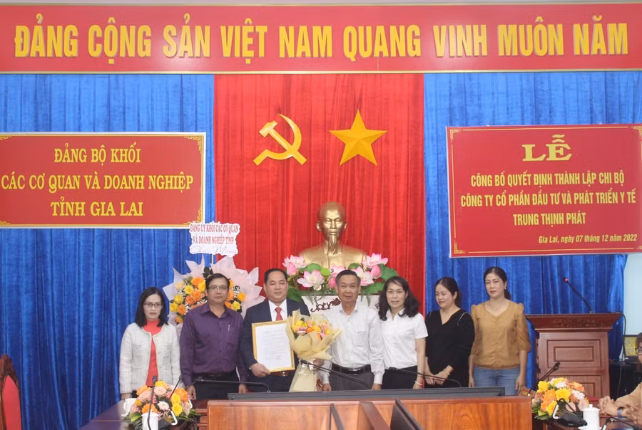 Đồng chí Huỳnh Tấn Đoan (ở giữa)-Phó Bí thư Đảng ủy Khối các Cơ quan và Doanh nghiệp tỉnh trao quyết định thành lập cho Chi bộ Công ty Cổ phần Đầu tư và Phát triển Y tế Trung Thịnh Phát. Ảnh: Phan Lài