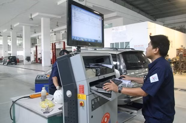 Đăng kiểm viên kiểm tra thông số kỹ thuật xe ôtô qua hệ thống máy tính. (Ảnh: Hoàng Hùng/TTXVN)