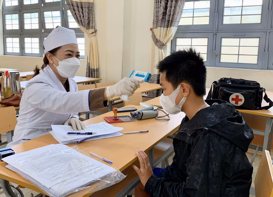Nhân viên y tế phường Hội Thương, TP. Pleiku khám sàng lọc trước khi tiêm vắc xin phòng Covid-19 cho trẻ. Ảnh Như Nguyện