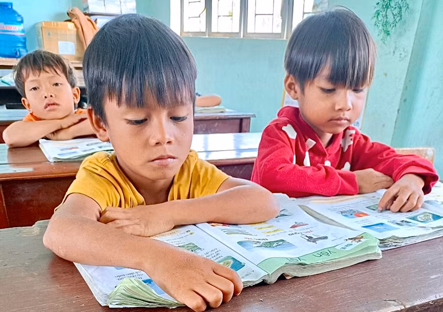  Học sinh lớp 1 của Trường Phổ thông Dân tộc Bán trú Tiểu học và THCS Sró (huyện Kông Chro) sử dụng sách giáo khoa từ Tủ sách dùng chung để học tập. Ảnh: Mộc Trà