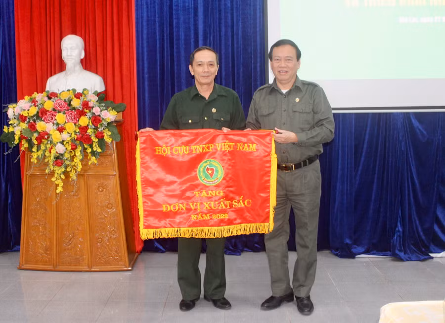 Đồng chí Vũ Trọng Kim (bìa phải)-Chủ tịch Hội Cựu TNXP Việt Nam tặng cờ thi đua đơn vị xuất sắc năm 2022 cho Hội Cựu TNXP tỉnh Gia Lai. Ảnh: Phan Lài