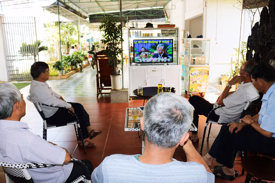 Người dân tổ 4, phường Thắng Lợi, thành phố Pleiku theo dõi diễn biến của Đại hội Đảng bộ tỉnh qua sóng truyền hình. Ảnh: Ngọc Sang