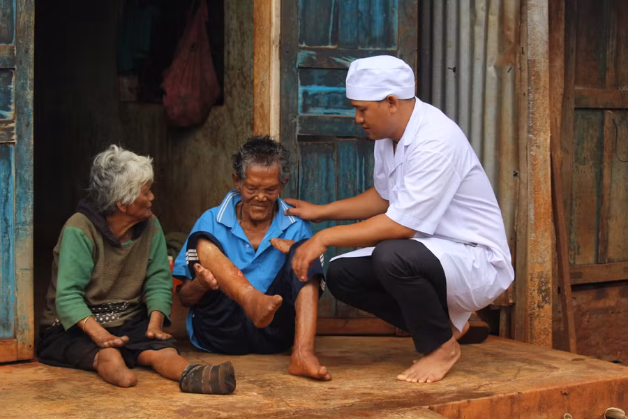 Bác sĩ A Mlum-cán bộ chuyên trách phòng-chống bệnh phong của Trung tâm Y tế huyện Đak Đoa-thăm bệnh cho ông Vêuh và bà Bao. Ảnh: Hoành Sơn