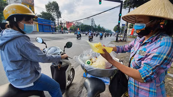 Chị Mến với thúng xôi nuôi con ăn học - Ảnh: MẠNG DŨNG