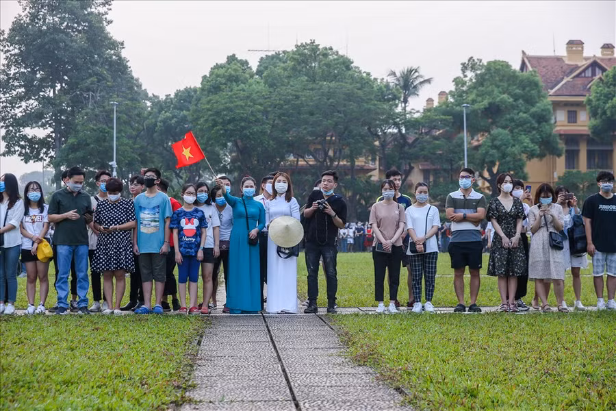 Người dân mặc áo dài truyền thống, mang theo cờ để thể hiện tình thần mùng 2.9.