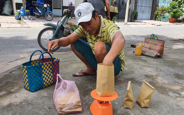 Tranh thủ lúc không có khách, anh Phong cân sẵn các gói hạt dẻ 20.000 đồng - Ảnh: MẠNH DŨNG