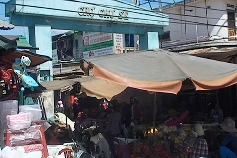 Các tiểu thương buôn bán ngay trước cổng chợ, sát với lòng đường quốc lộ 14. Ảnh: Công Dũng