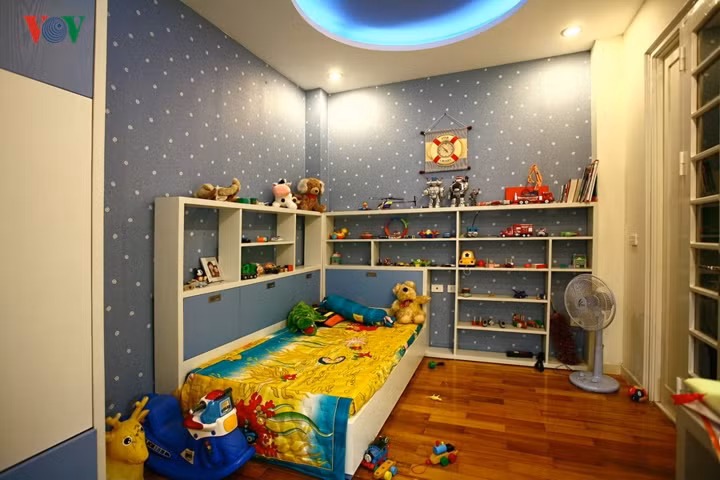  Góc chết do cột lồi ra ở góc phòng, nhà thiết kế đã dùng hai chiếc kệ bằng đúng phần lồi ra để trả lại sự vuông vắn của góc nhà.