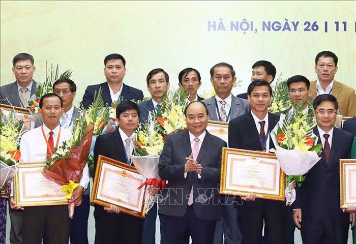 Thủ tướng Nguyễn Xuân Phúc trao tặng Bằng khen cho các tập thể có thành tích xuất sắc trong thực hiện Nghị quyết Trung ương 7 (Khóa X). Ảnh: Thống Nhất/TTXVN