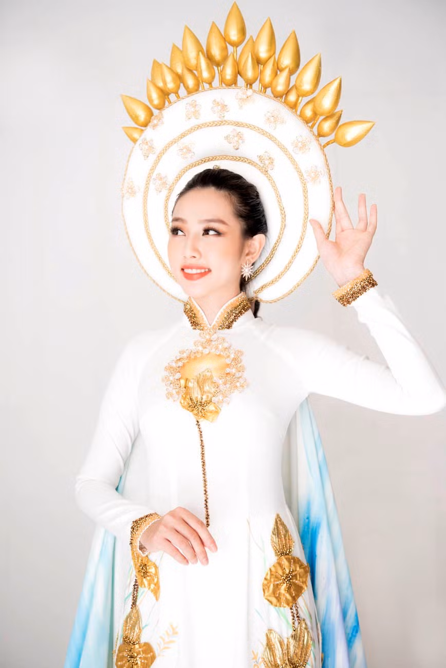  Bộ trang phục với đầu đội khăn vấn kết hợp với trâm cài lược dắt như hình ảnh Hoàng Hậu ngày tấn phong ngôi vị… với hy vọng cô gái Thùy Tiên sẽ mang sắc vóc Việt Nam đến gần hơn với bạn bè thế giới. (Ảnh: Mon Trần)