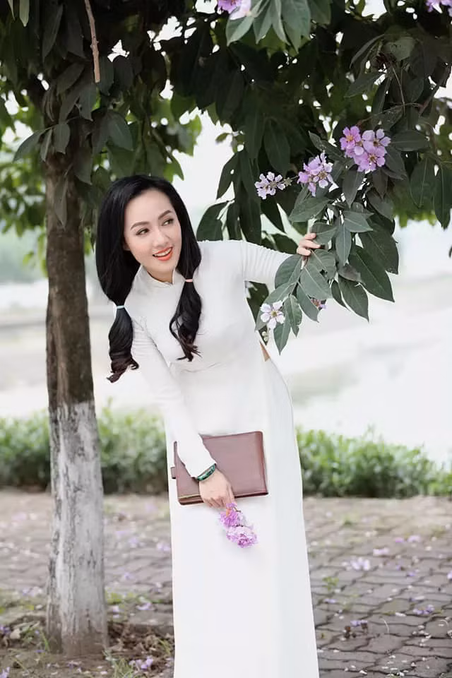 Mới đây, BTV Hoài Anh đăng tải loạt ảnh cô diện áo dài trắng bên hoa bằng lăng tím.