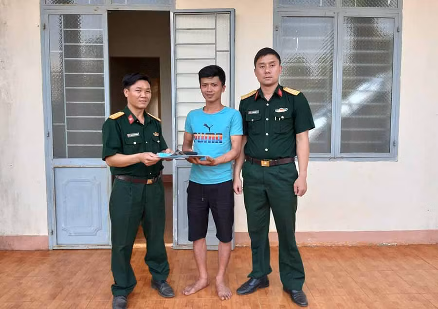  Trung úy quân nhân chuyên nghiệp Nguyễn Thế Dương trả lại chiếc ví cho anh Hoàng Văn Nam trước sự chứng kiến của đại diện cơ quan chính trị Lữ đoàn PPK 234. Ảnh: Duy Hiển