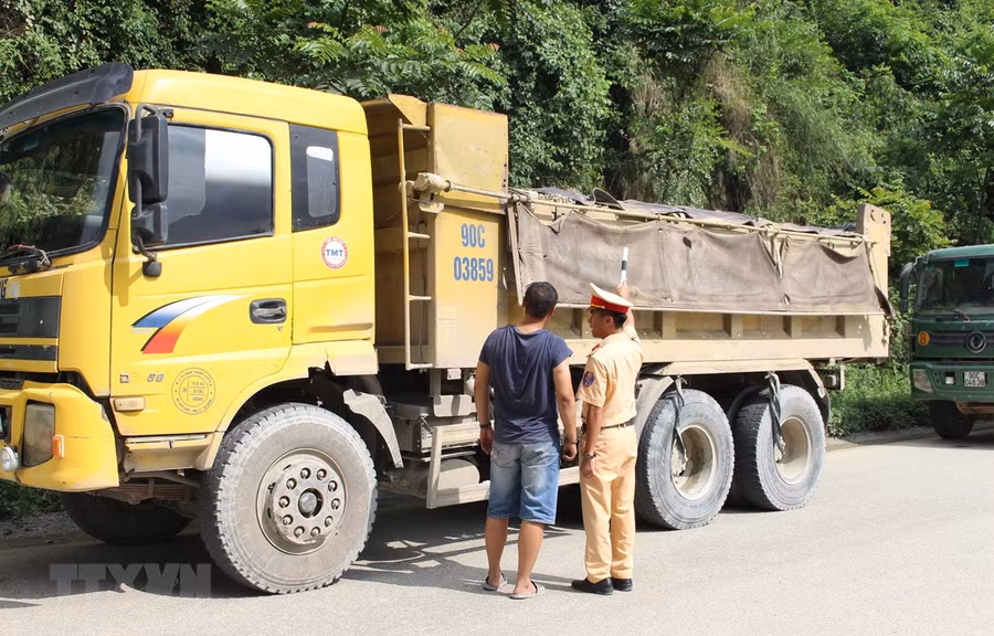 Cảnh sát giao thông kiểm tra một xe tải lưu thông trên đường. Ảnh minh họa. (Nguồn: TTXVN) Cảnh sát giao thông kiểm tra một xe tải lưu thông trên đường. Ảnh minh họa. (Nguồn: TTXVN)