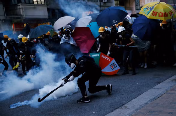 Người biểu tình phóng lựu đạn cay trong một cuộc xuống đường ở Hong Kong tháng 7-2019 - Ảnh: REUTERS