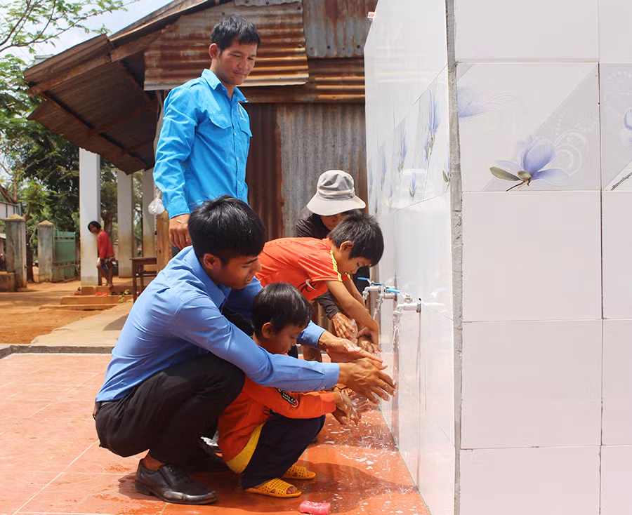  Người dân và các em nhỏ làng Alphun (xã Ia Pết, huyện Đak Đoa) sử dụng nước sạch từ công trình do ĐVTN thực hiện. Ảnh: P.L